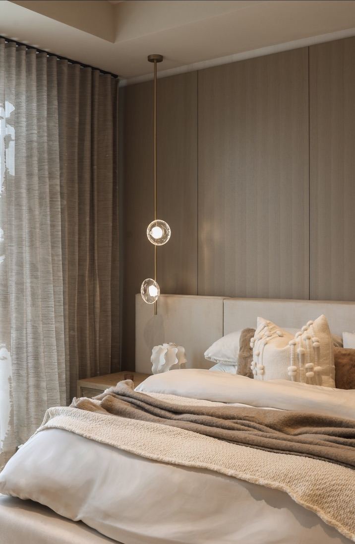 Primary bedroom with layered linens and drum pendant lighting
