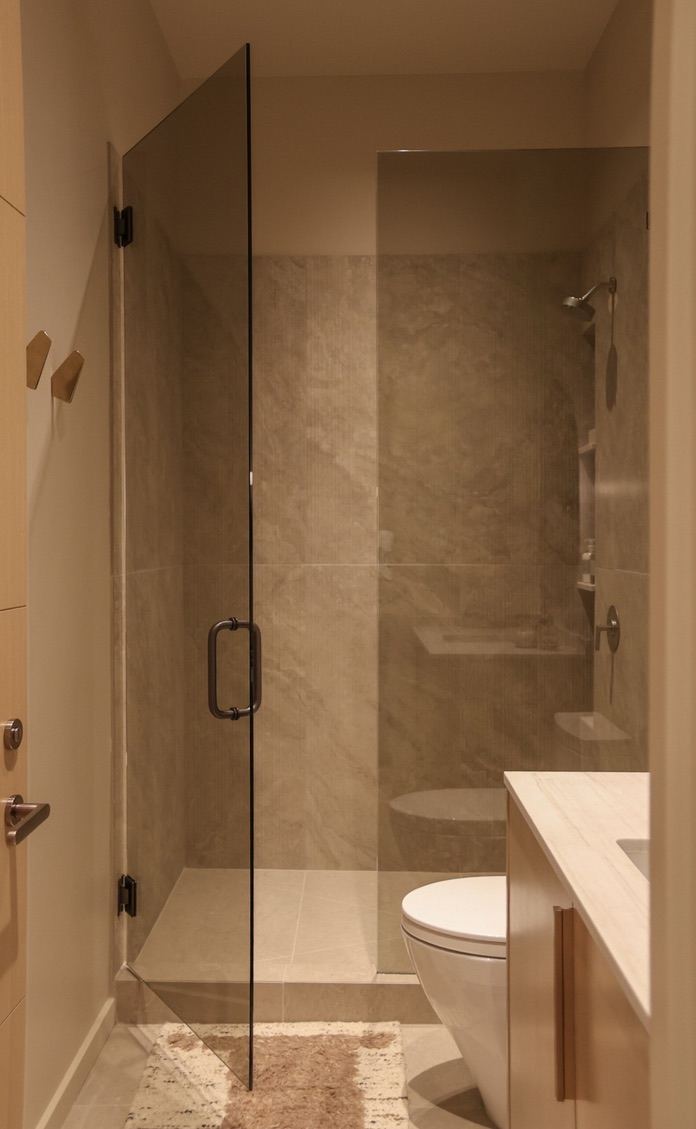 Glass shower and stone bath with woven rug