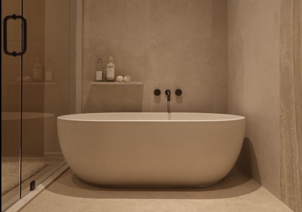 Freestanding soaking tub in stone bath