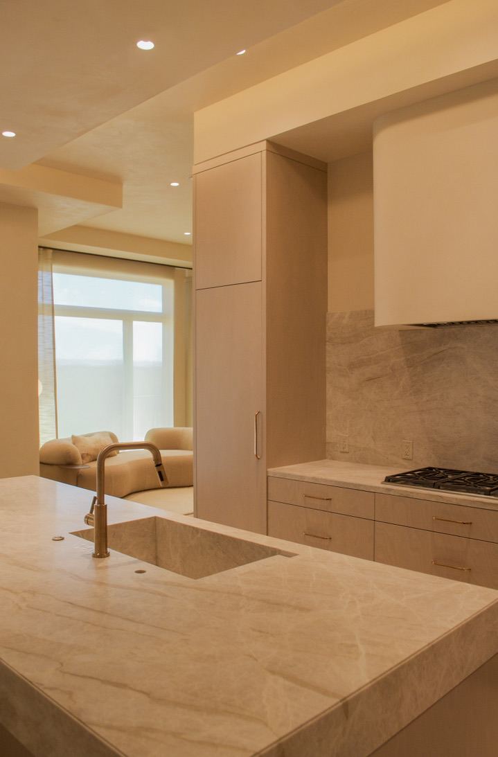 Kitchen with marble island and sculptural range hood